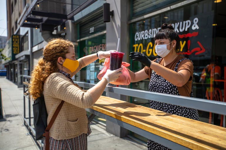 A woman picking up food at a restaurant during COVID-19