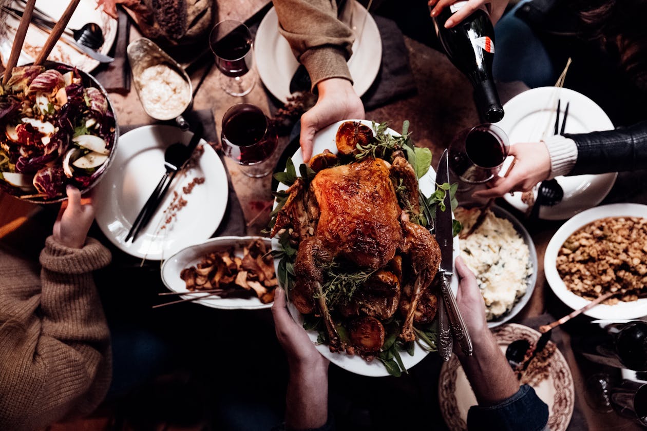 a group of people sitting at a table with plates of food