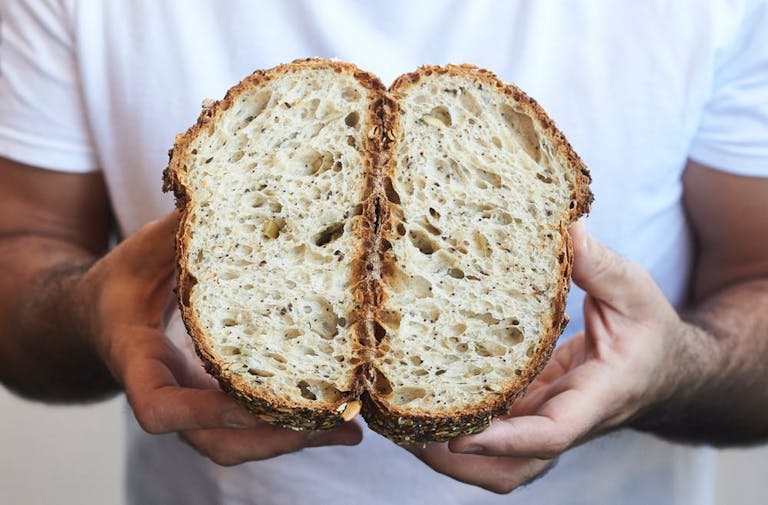 a person holding a loaf of bread