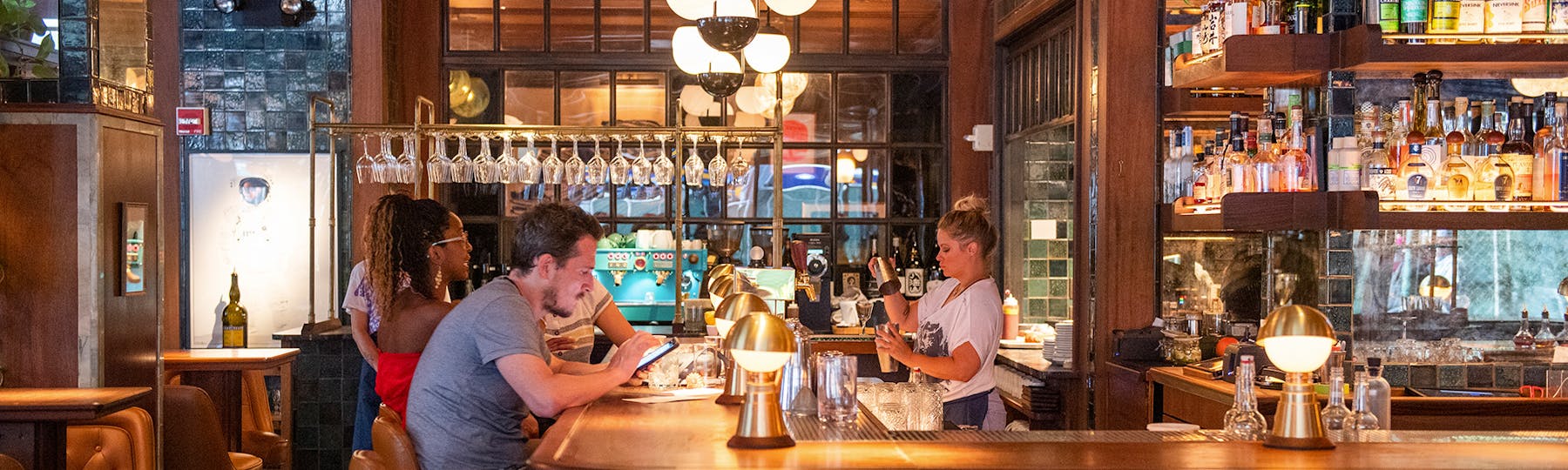 an elegant bar with guests and a bartender