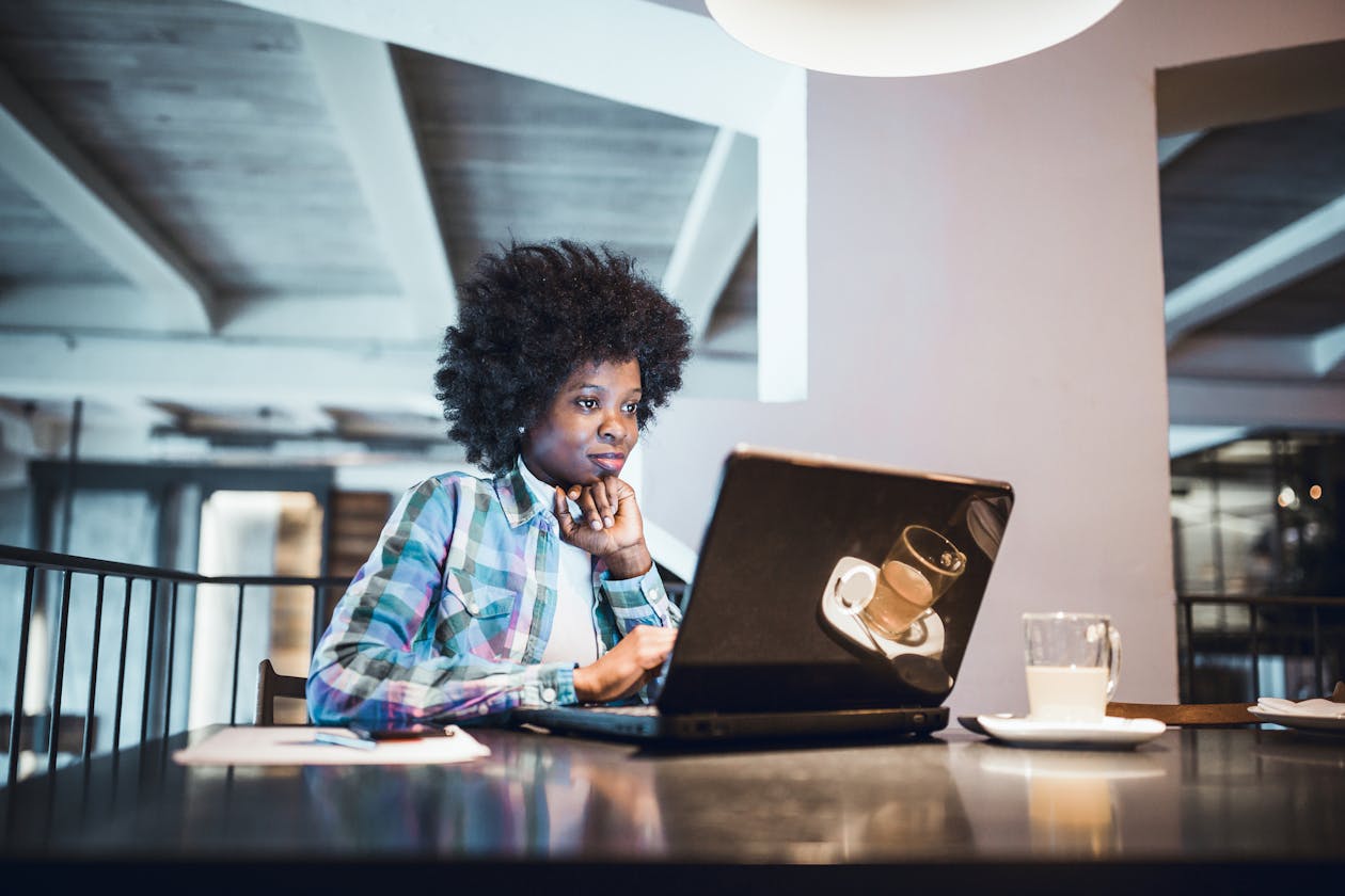 a woman sitting at a table using a laptop computer