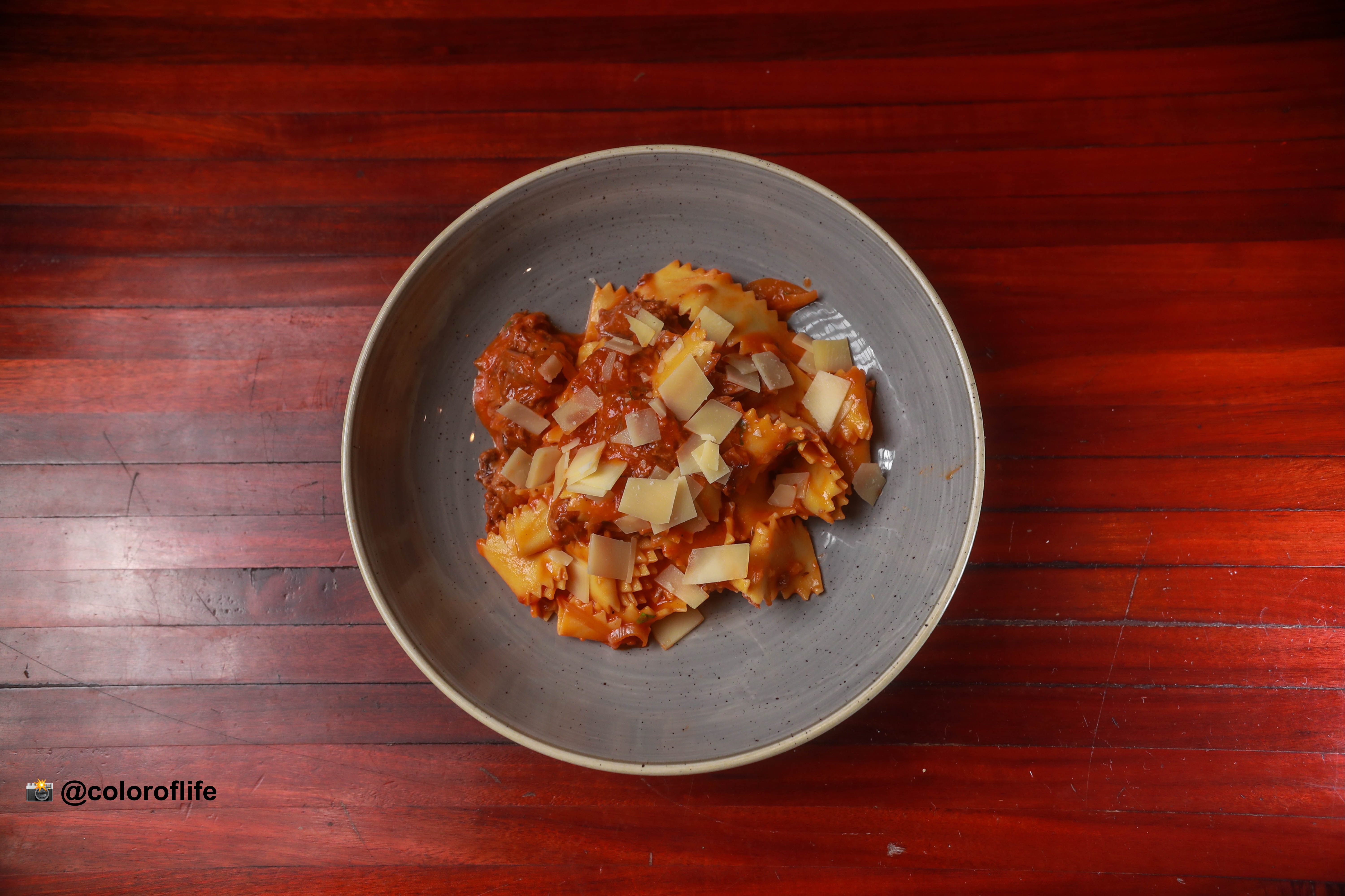 a bowl of food sitting on top of a wooden table