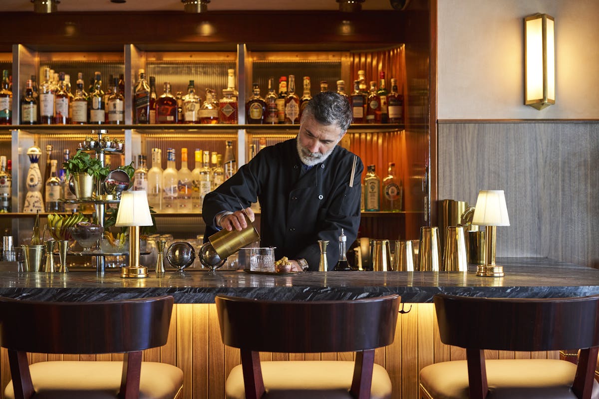 a man sitting at a table with wine glasses