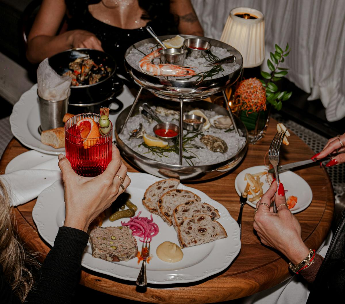 a group of people sitting at a table with a plate of food