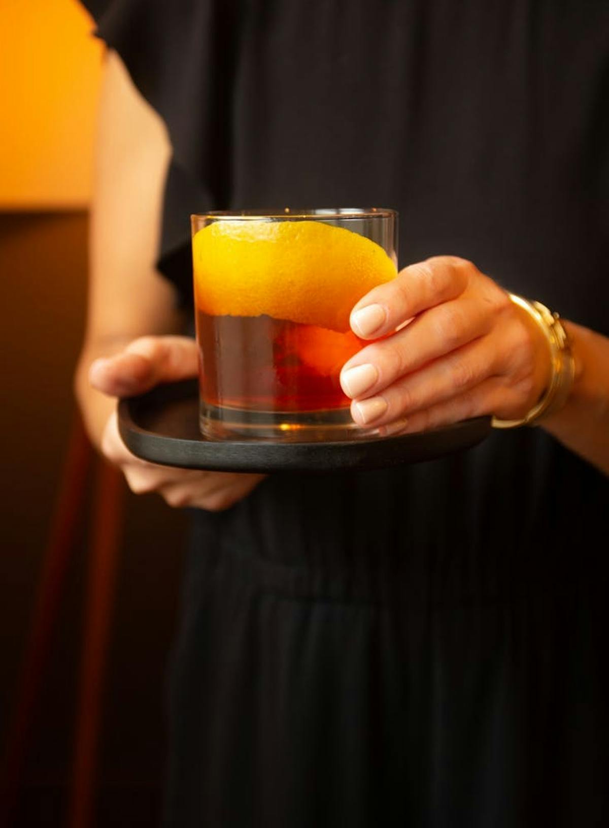 a hand holding a glass of orange juice