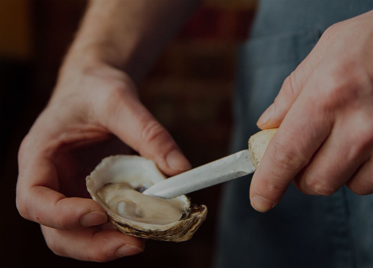 a man shucking an oyster