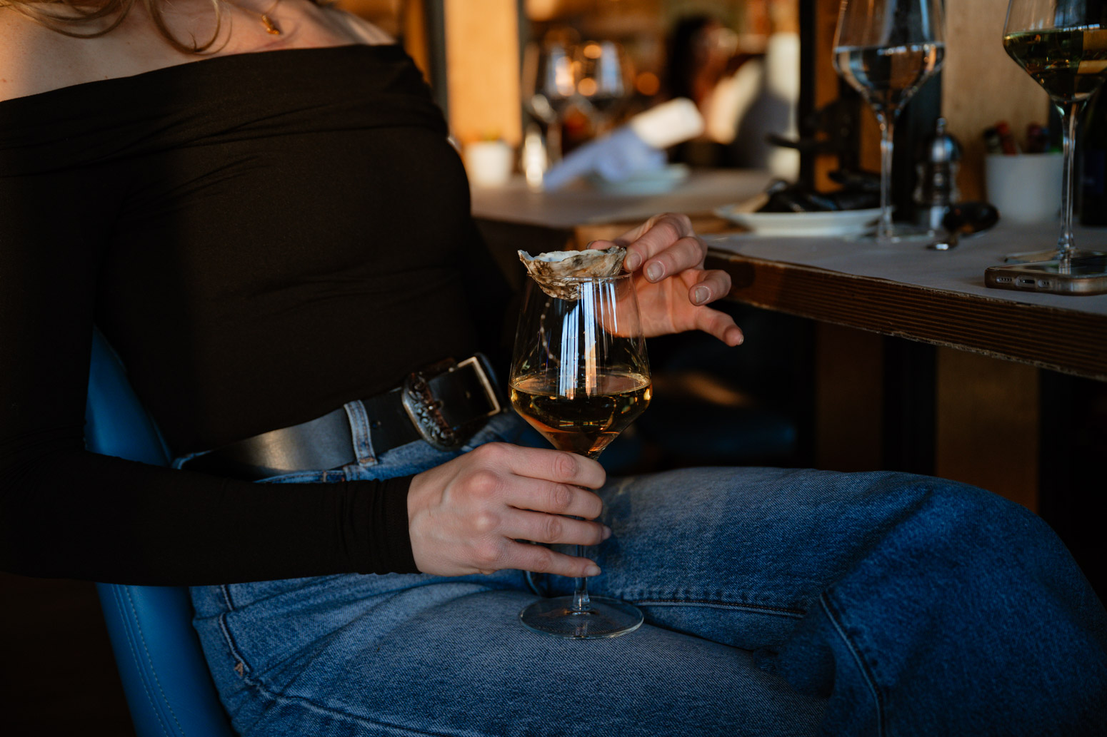 a person sitting at a table holding a glass of wine