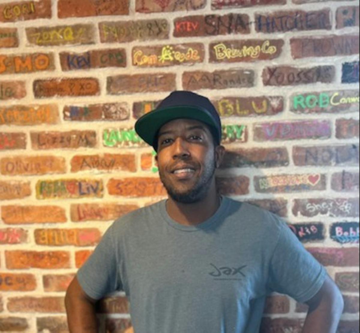 a man standing in front of a brick building