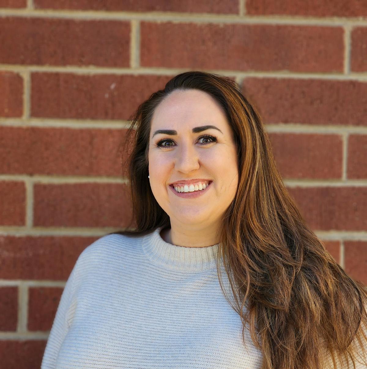 a person standing in front of a brick wall