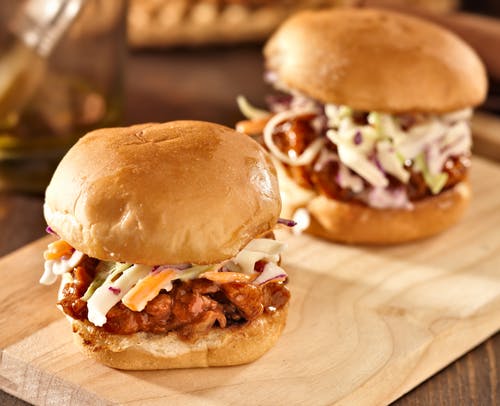 a close up of a sandwich sitting on top of a wooden cutting board