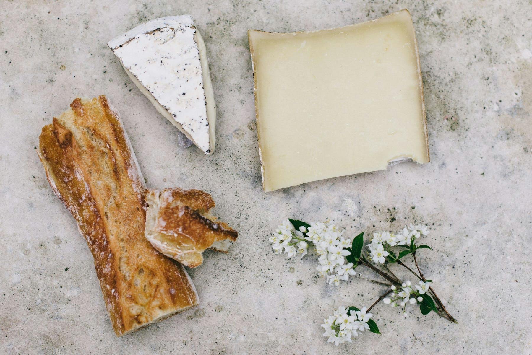 several types of bread on a white table next to flowers