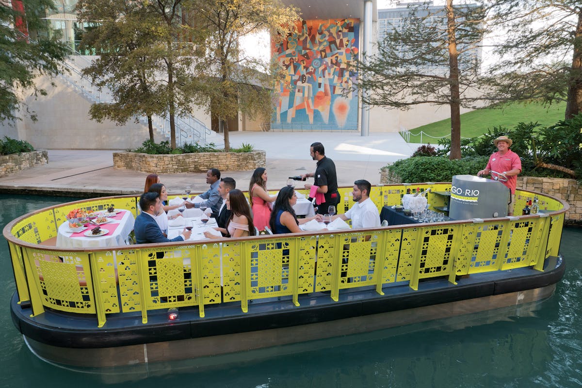 a group of people on a boat filled with logs