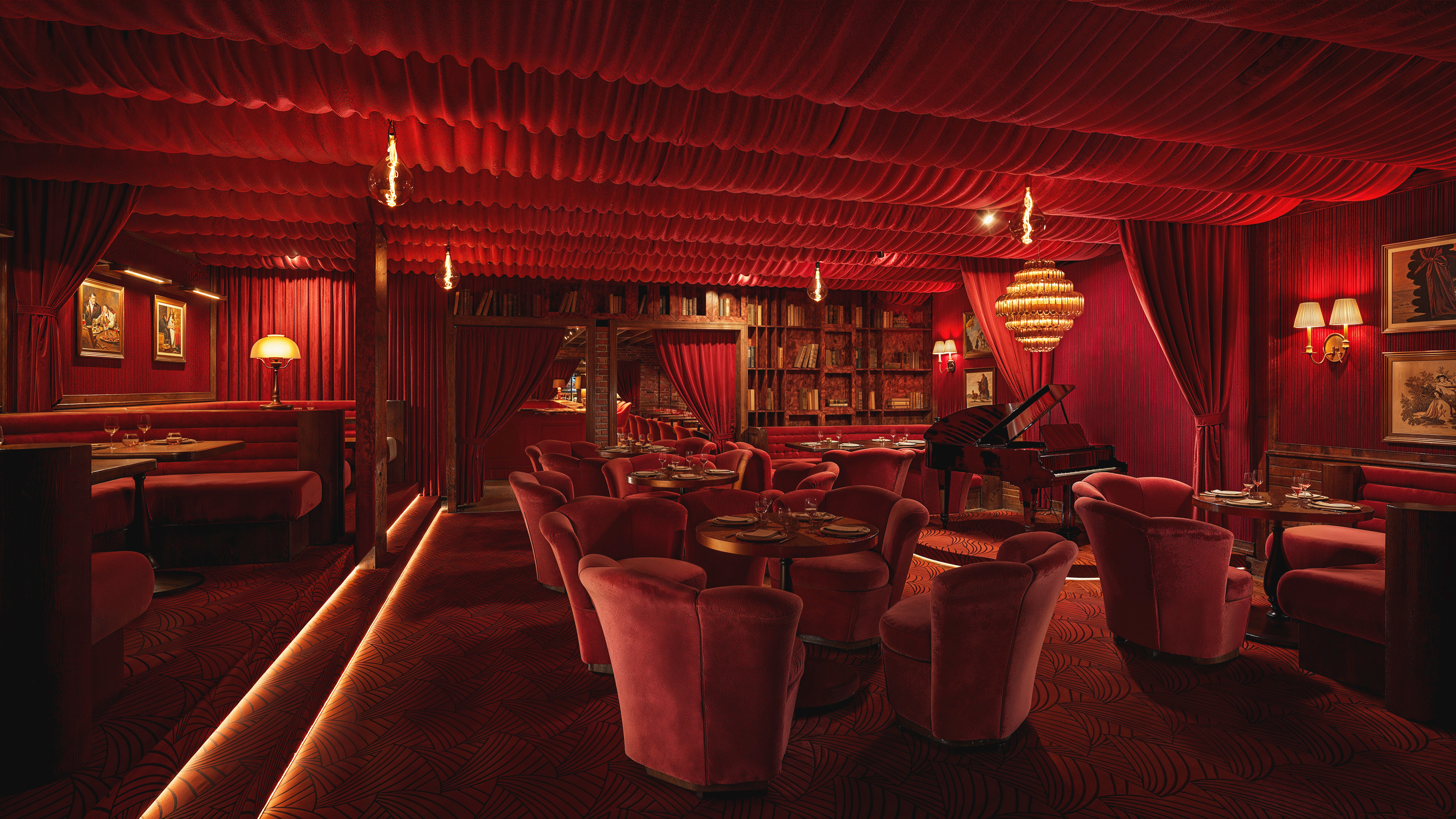 a room with red curtains and tables and chairs