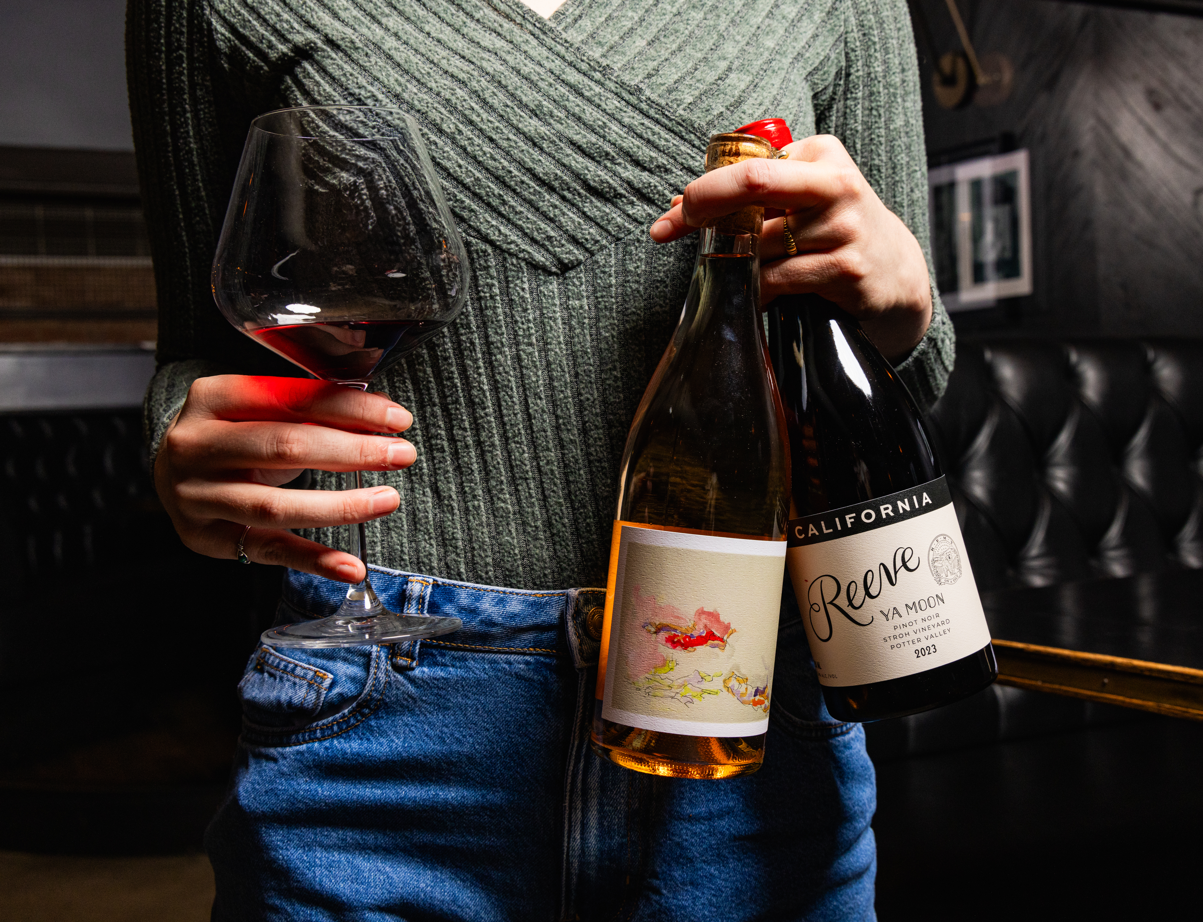 a person holding bottles of wine