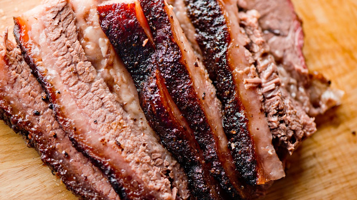 a piece of meat on a cutting board with a cake