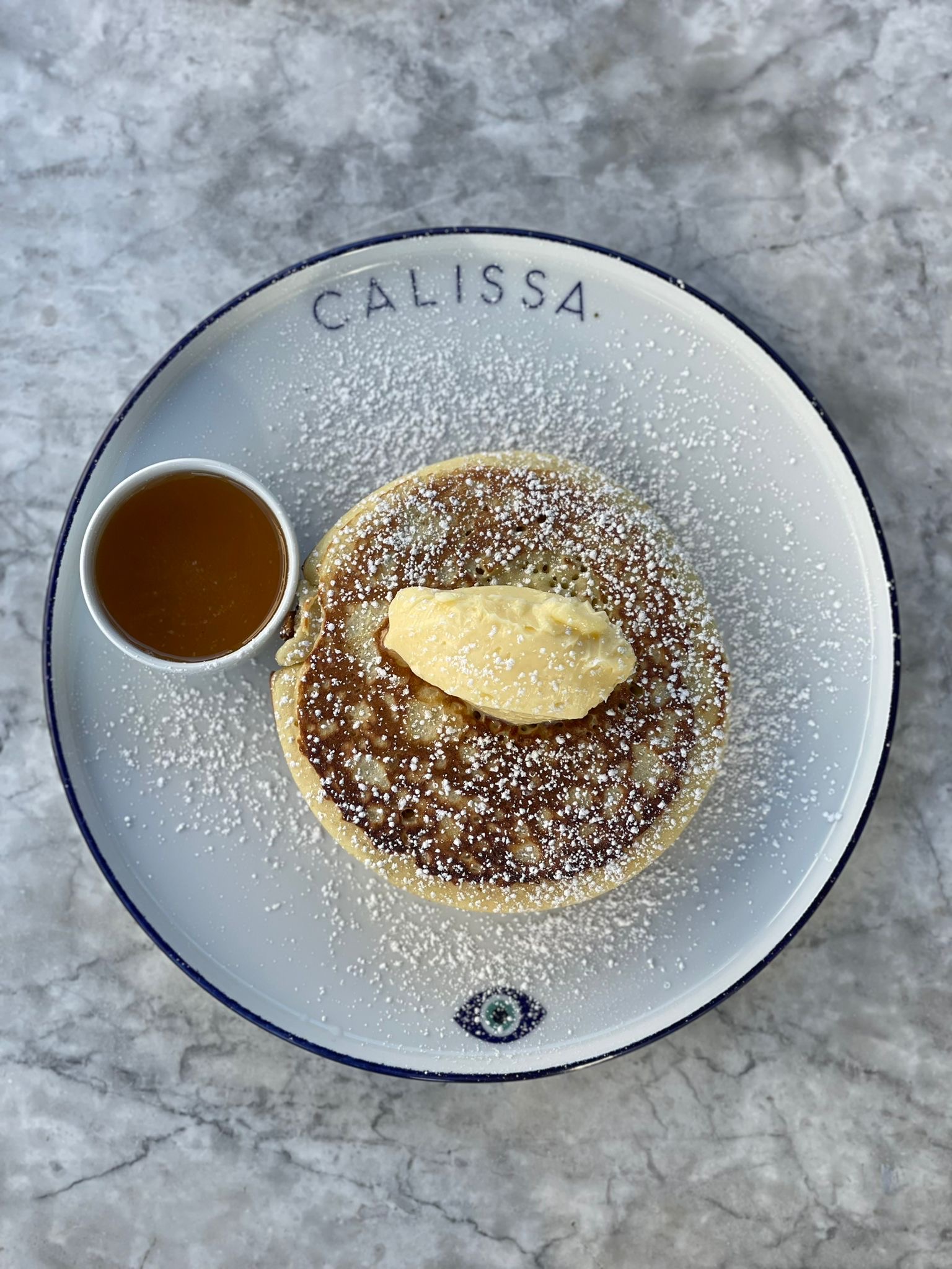 a plate of food with a small cup of syrup