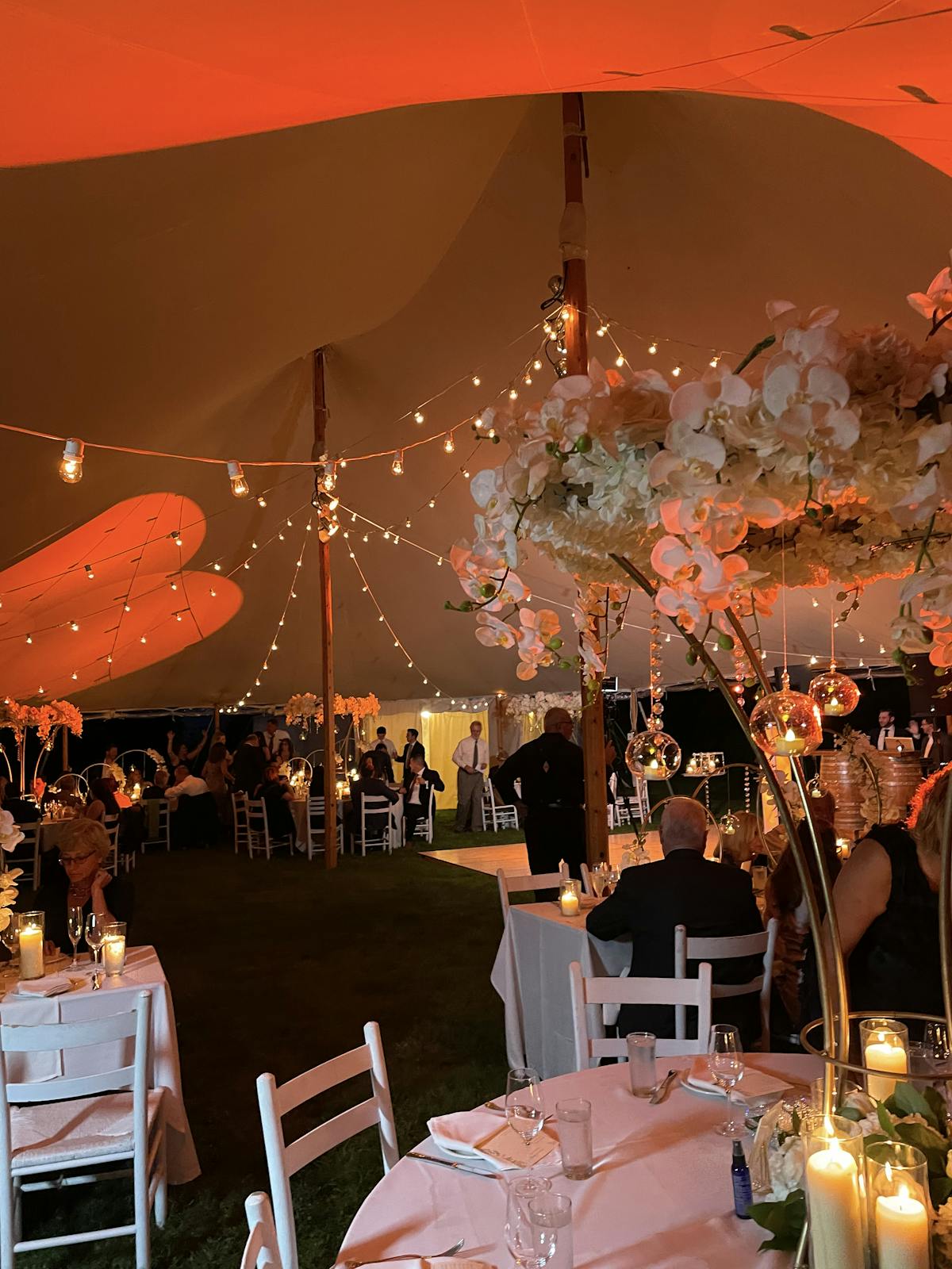 a group of people sitting around a dinner table umbrella
