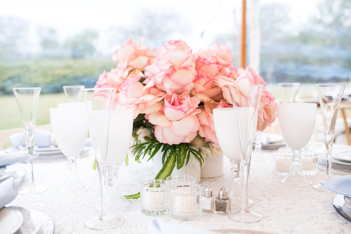 a bouquet of flowers on a table with wine glasses
