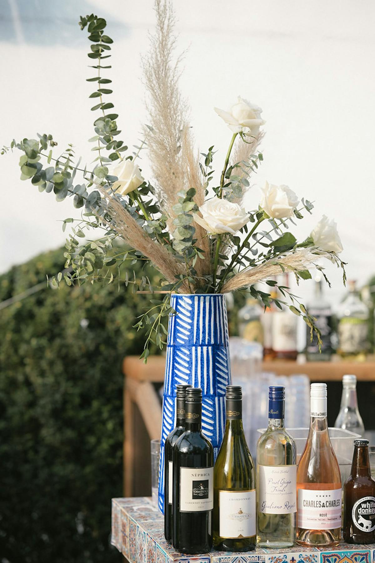 a bottle of wine and a vase of flowers on a table