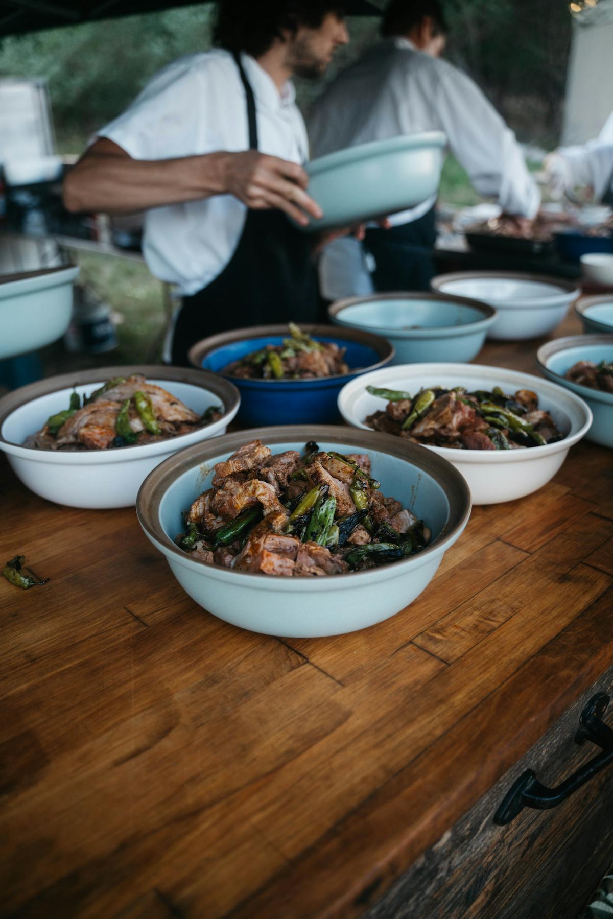 a group of people sitting at a table with a bowl of salad