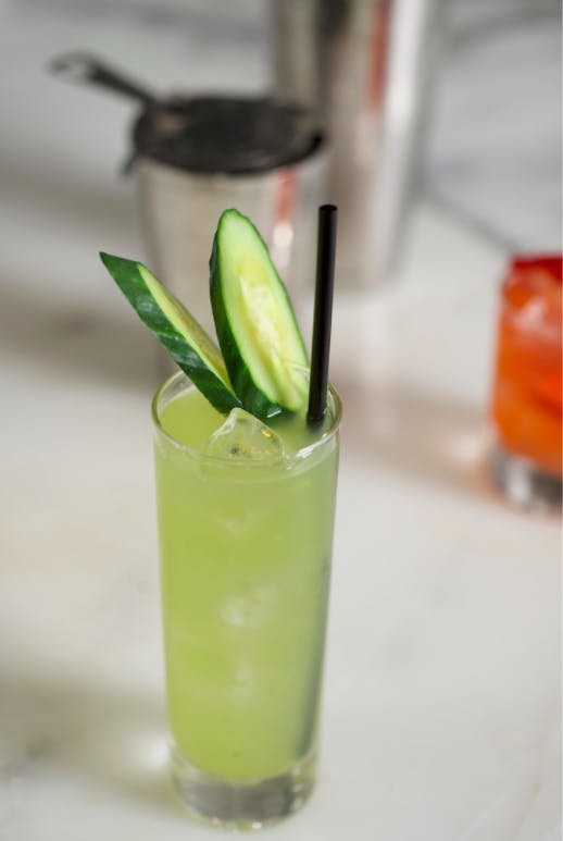 a green cocktail with cucumber