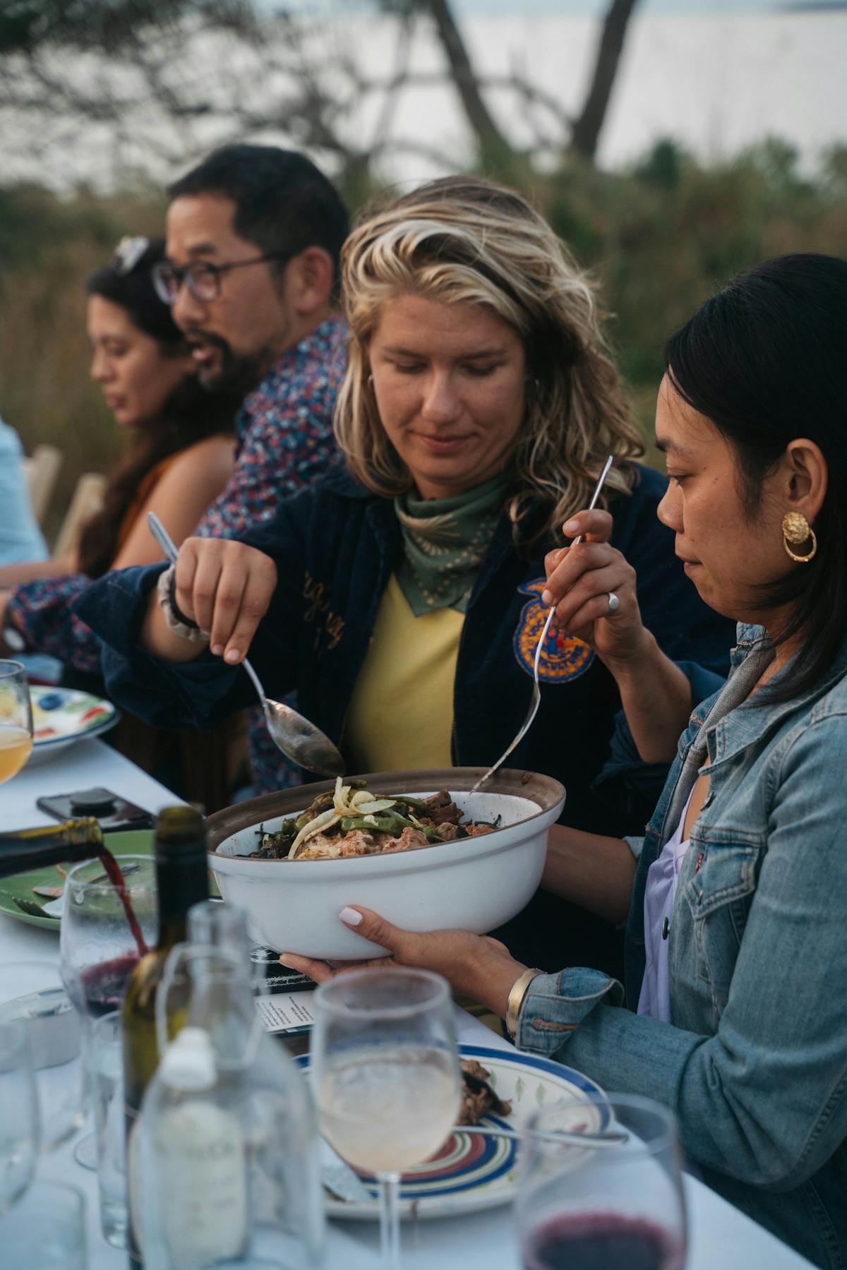 a group of people sitting at a table eating food