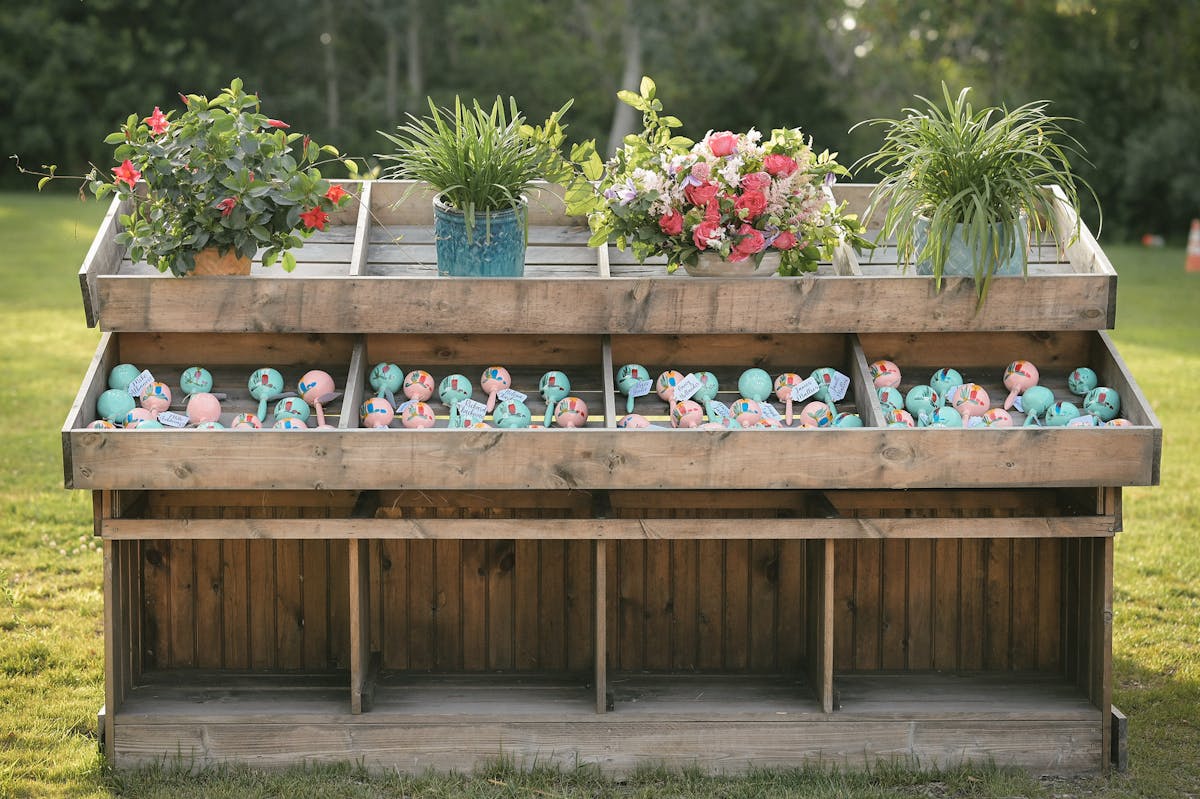 a vase of flowers sitting on top of a wooden bench