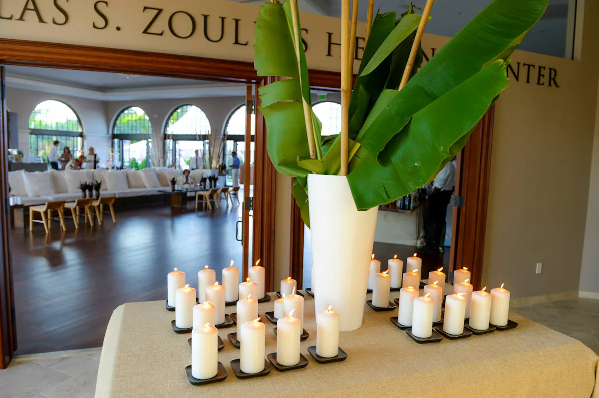 candles and a vase of leaves on a table