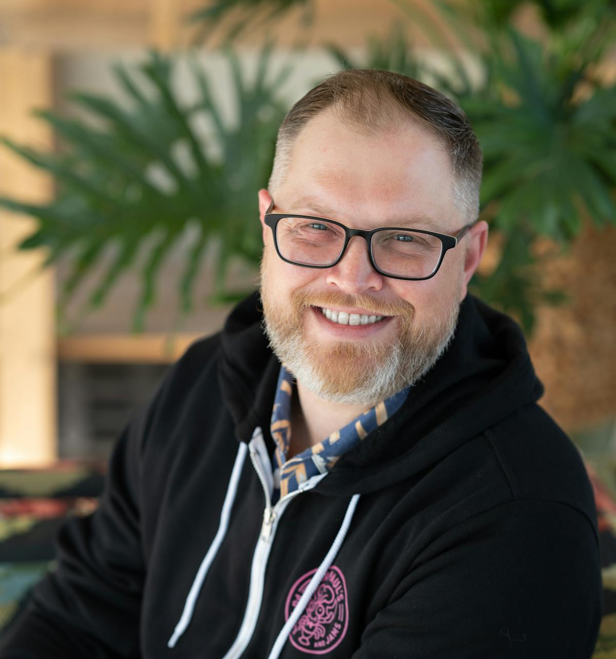 a man wearing glasses and smiling at the camera