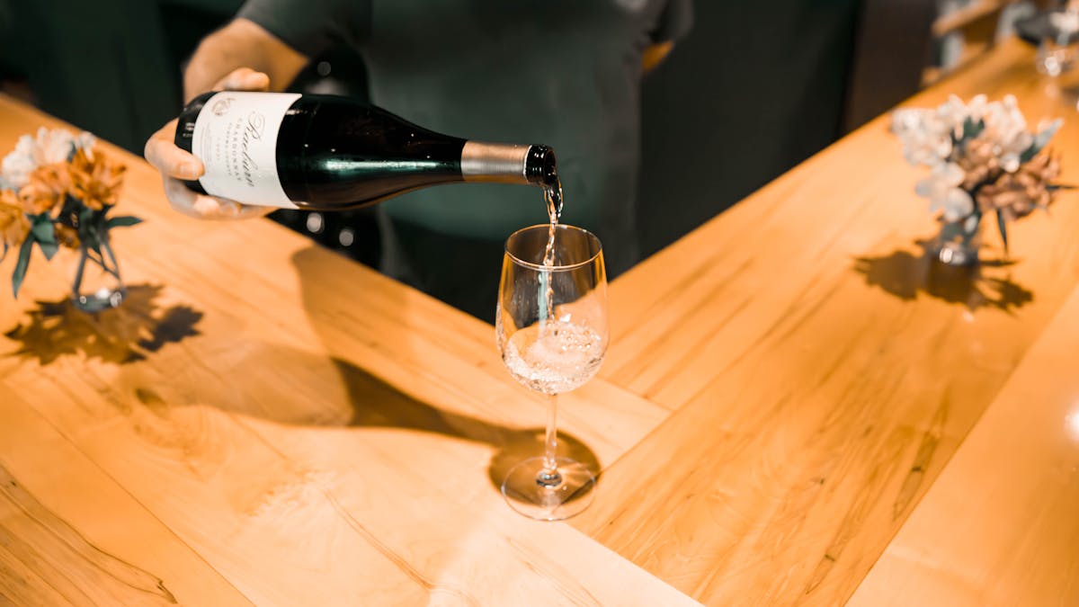 a glass of wine sitting on top of a wooden table