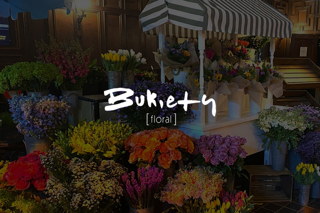 Bukiety logo over a flower cart overflowing with fresh cut flowers