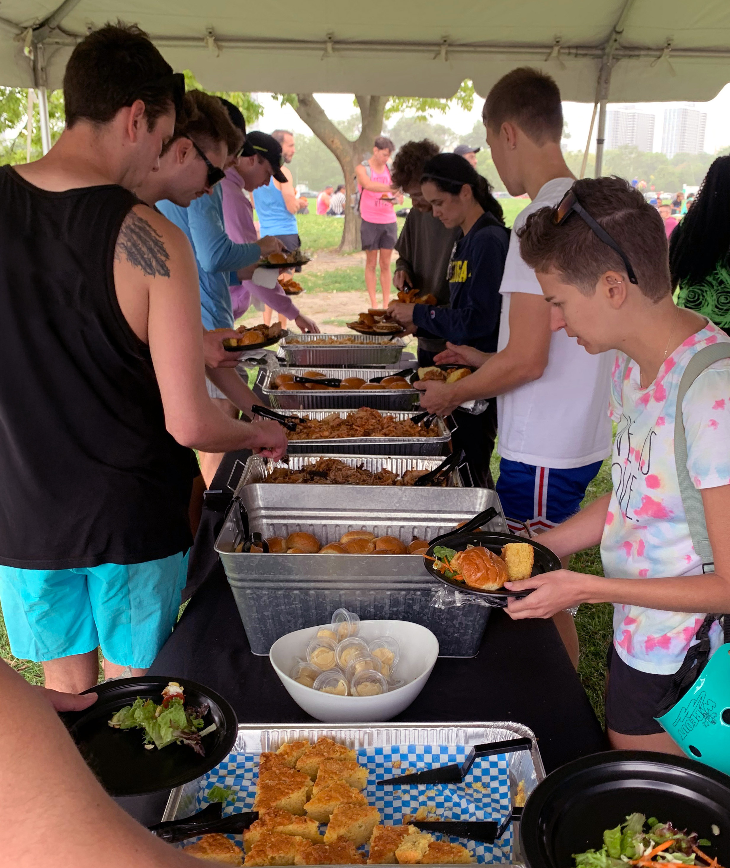 A line of people serving themselves at the buffet