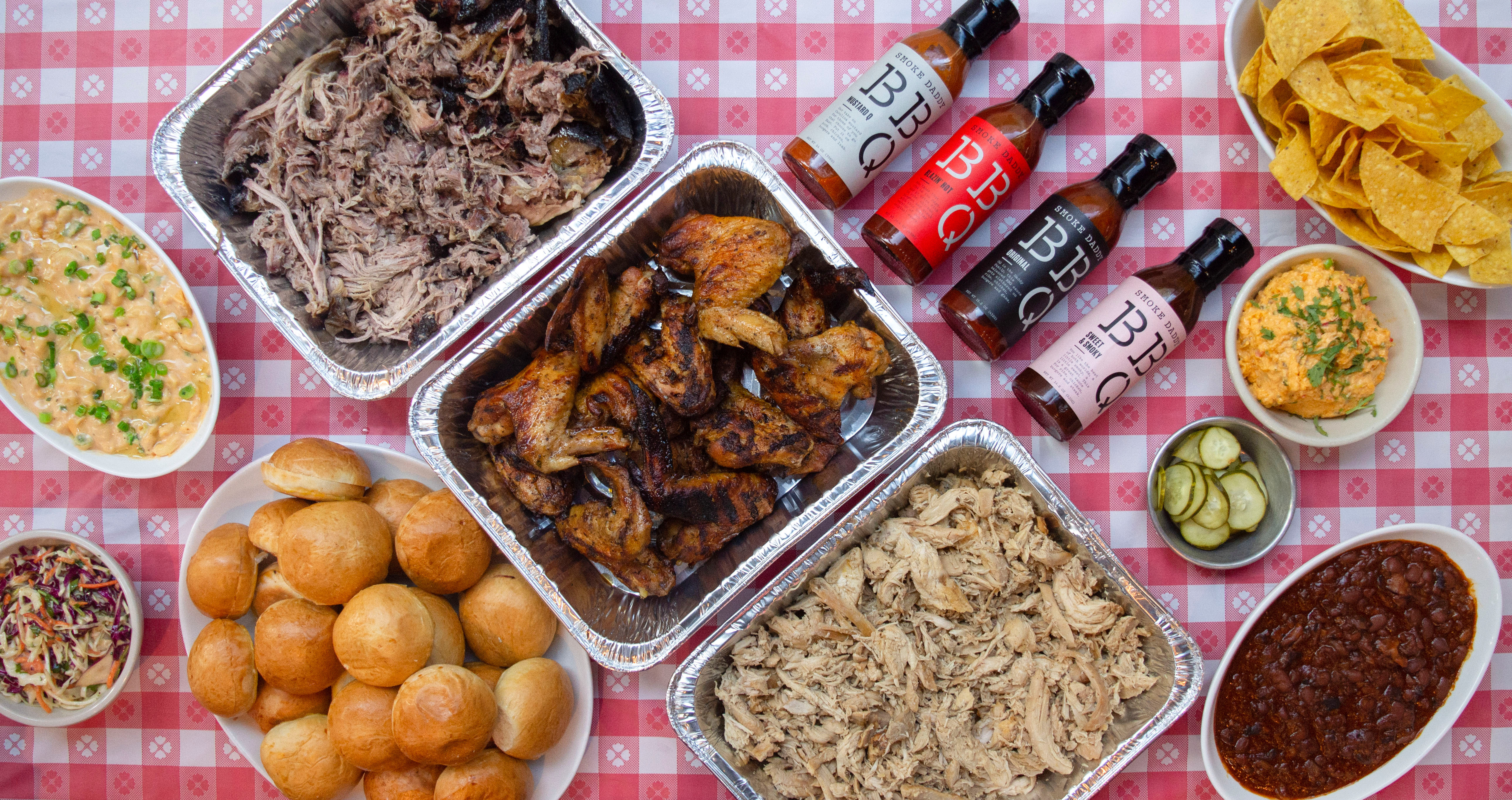 Red and white tablecloth set with BBQ in catering pans