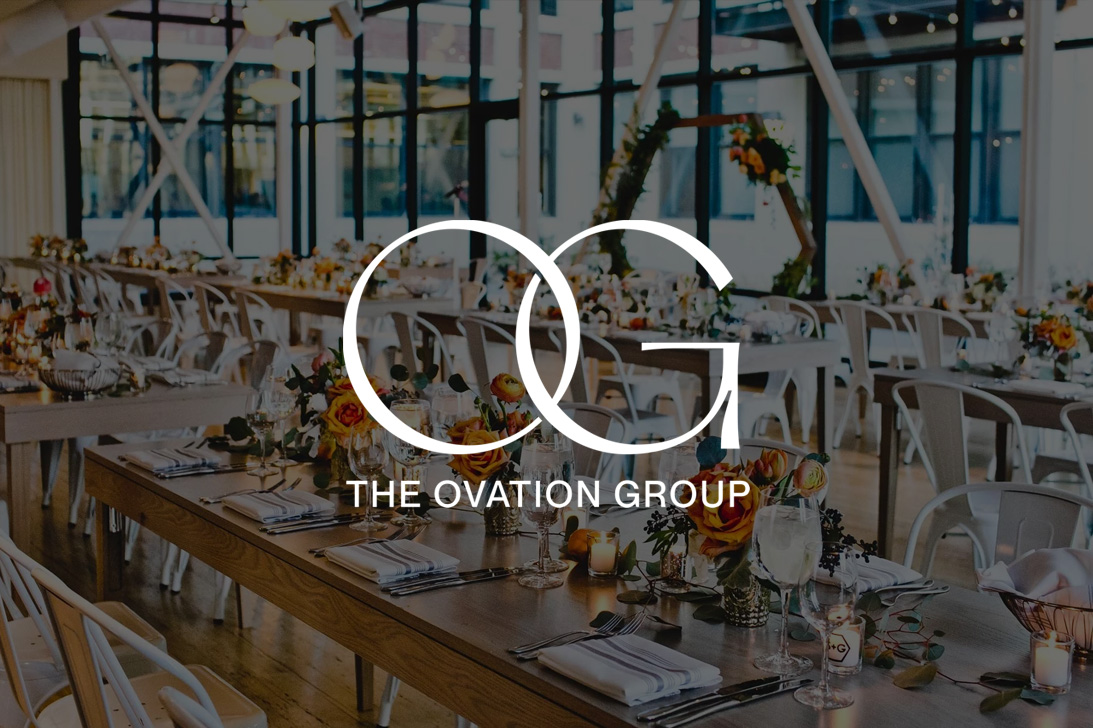 Ovation Group logo over a photo of a converted loft space, set with tables, placesettings, and orange flowers
