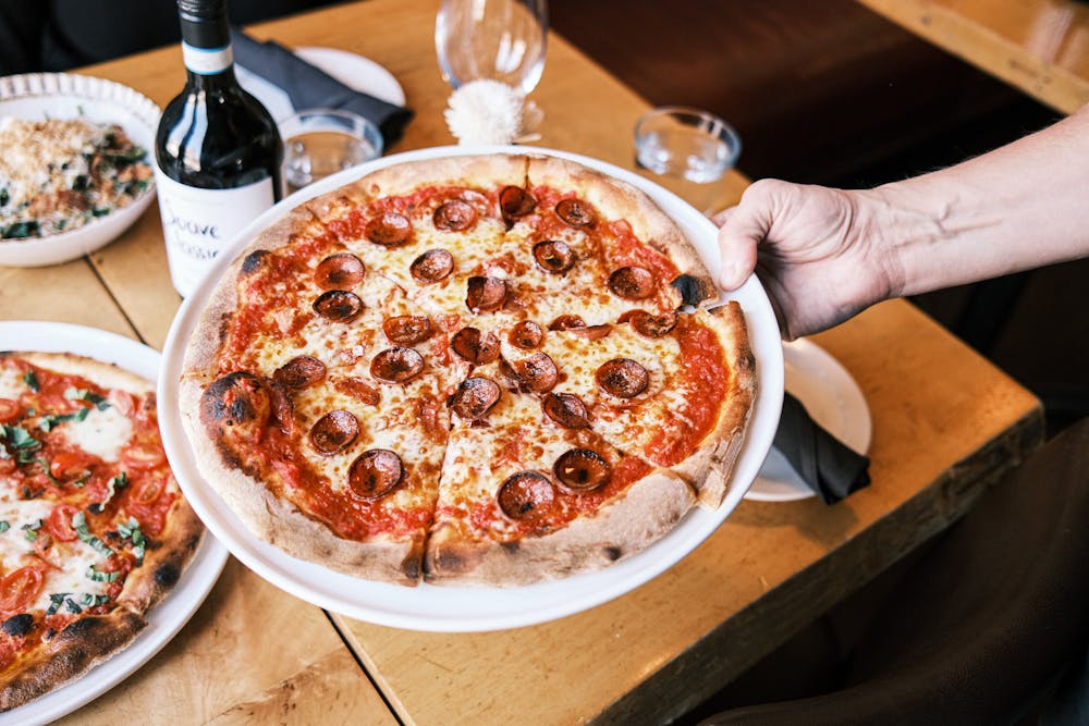 a pizza sitting on top of a wooden table
