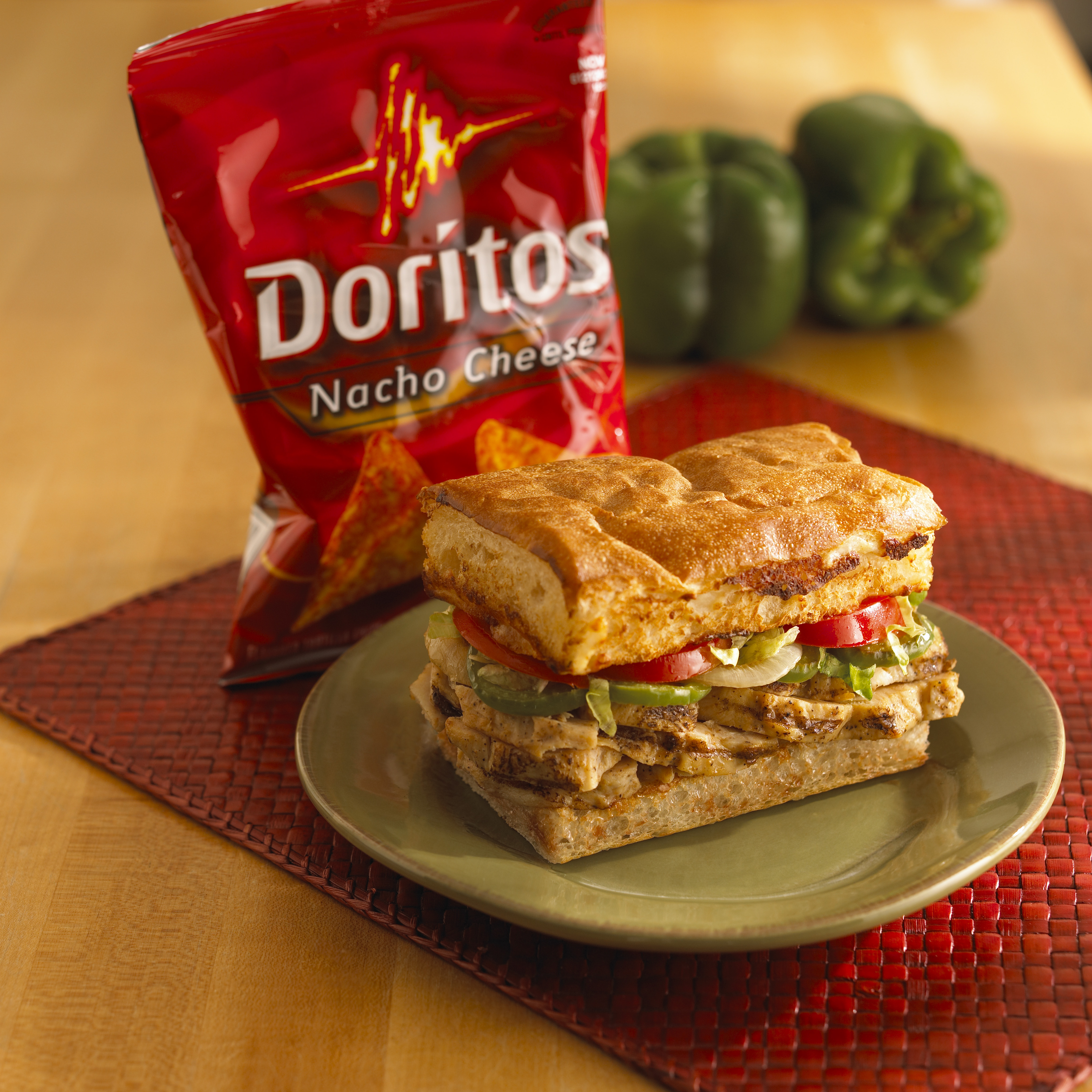 a sandwich on a plate next to a bag of chips