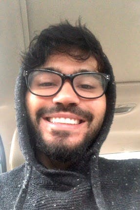a man wearing glasses and smiling at the camera