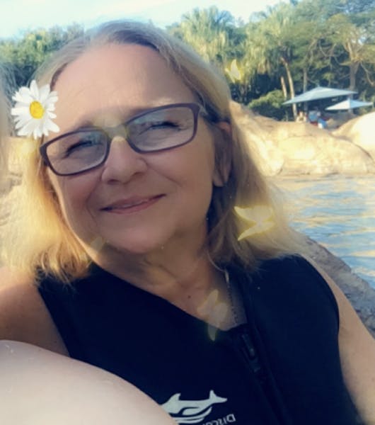 a woman wearing glasses and smiling at the camera