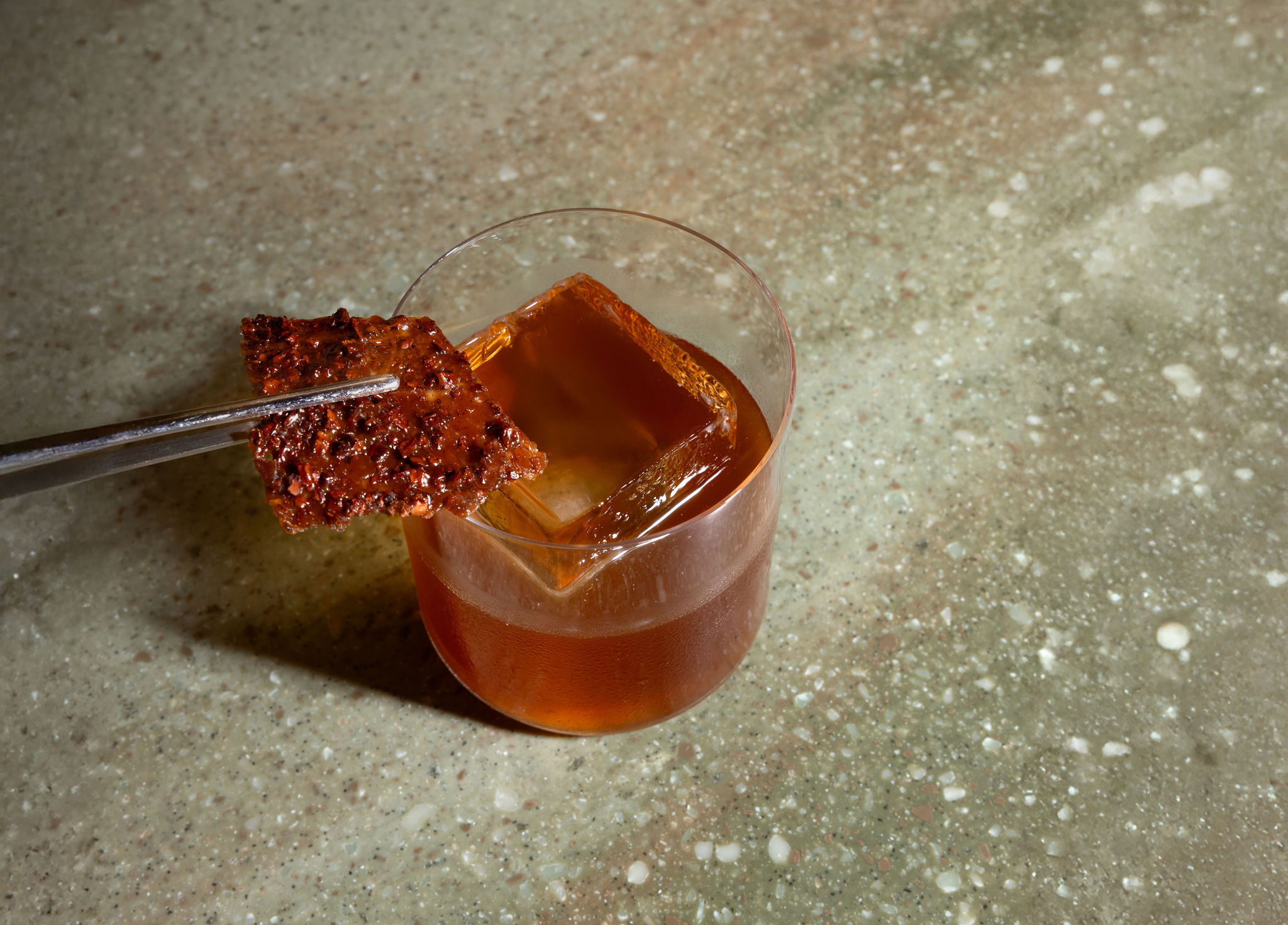 Signature Old Fashioned cocktail with ice cube and spiced garnish at Markette Restaurant Chelsea NYC — ideal for pre-dinner drinks near Madison Square Garden.