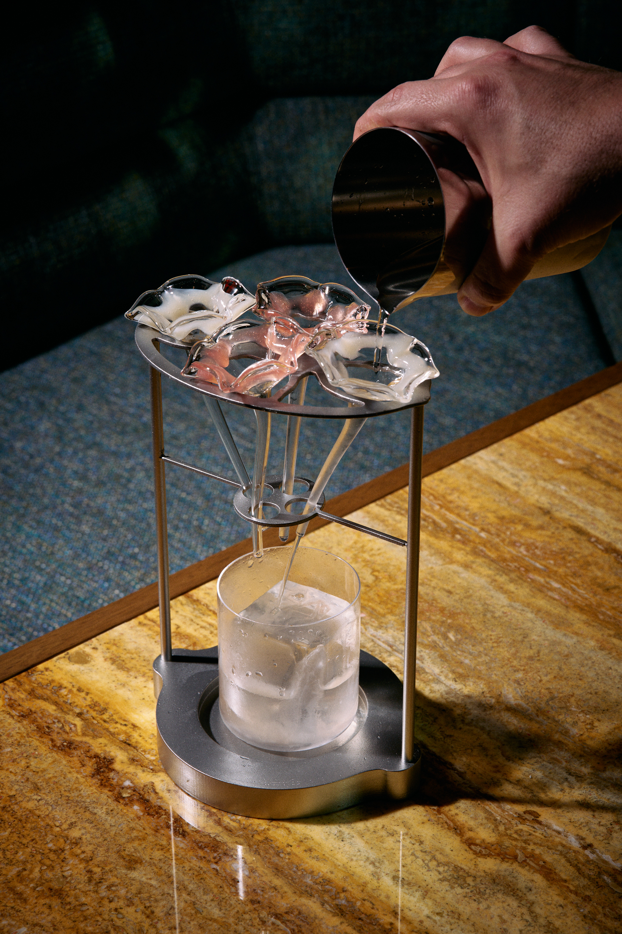 a hand pouring liquid into a glass