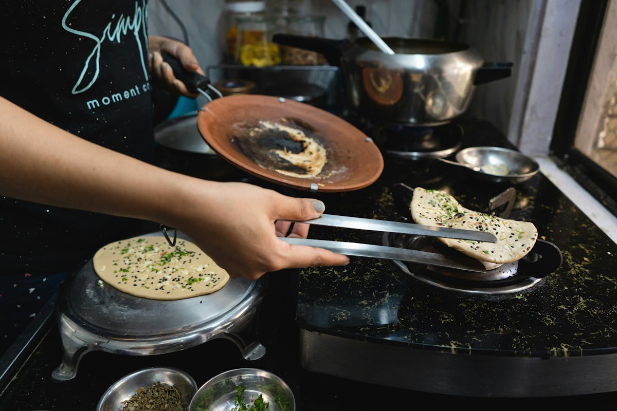 a person cooking food in a pan on a stove