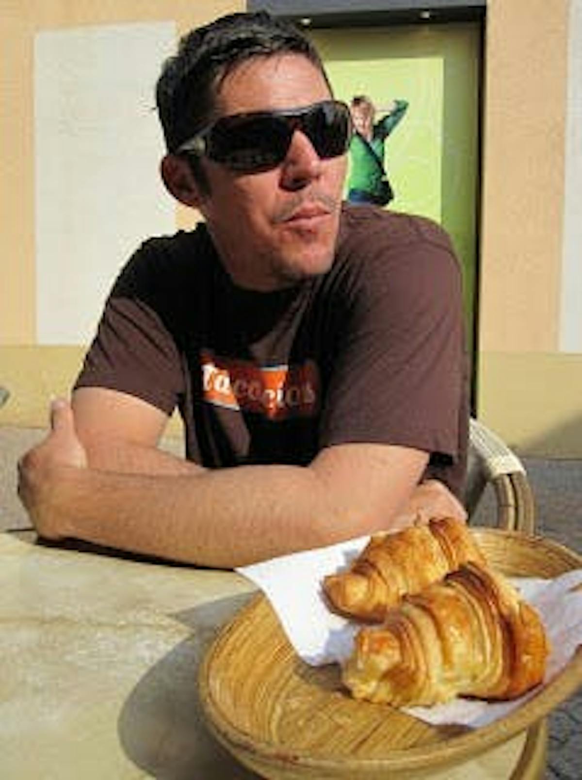 a man wearing glasses and two breads beside him