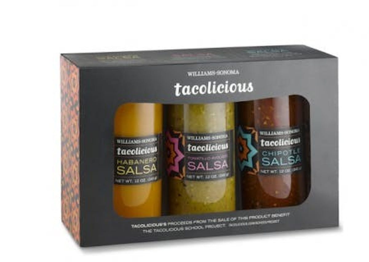 three glass bottles with sauce in it, inside a black box