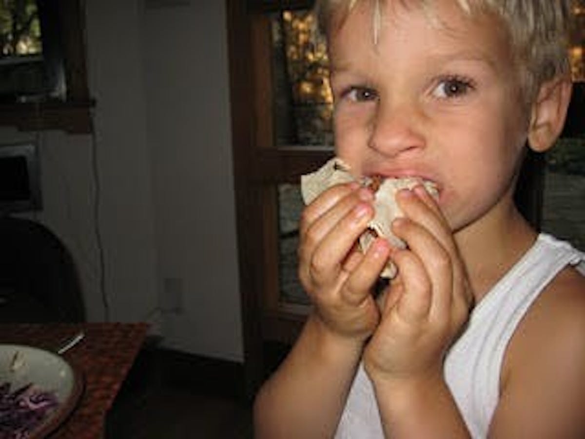 a kid eating a taco