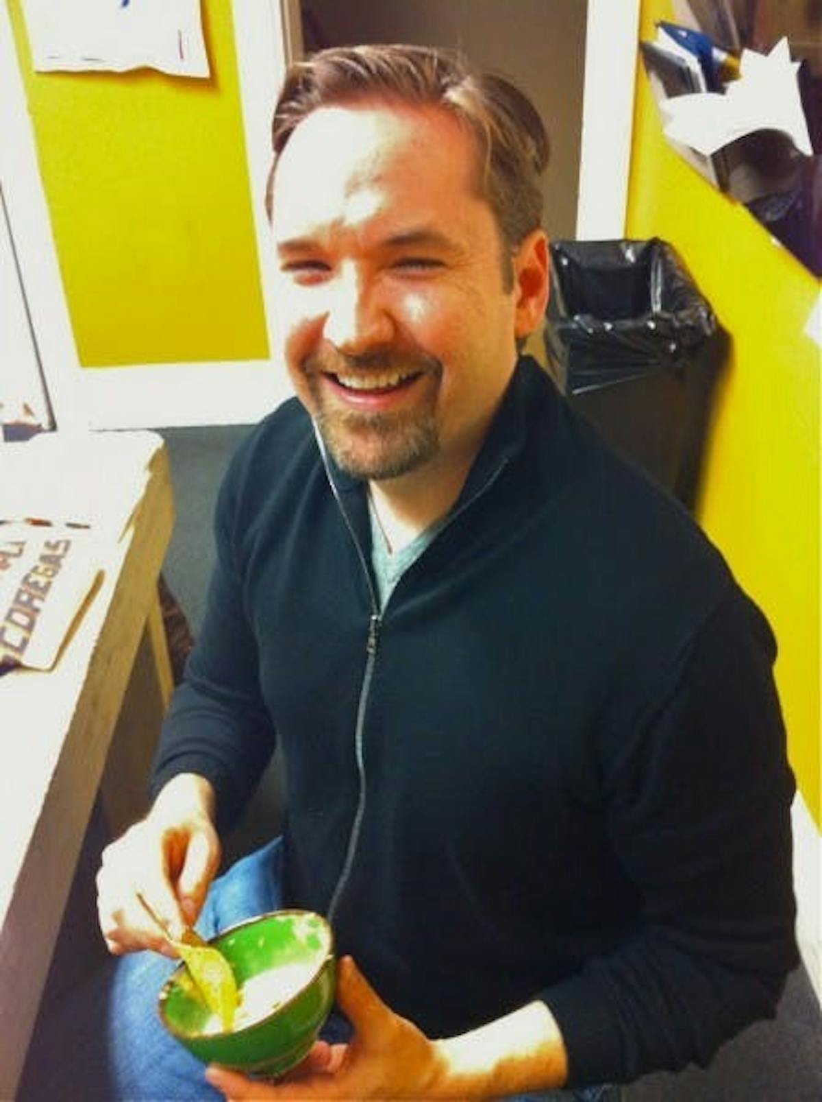 a man eating cheese dip with chips