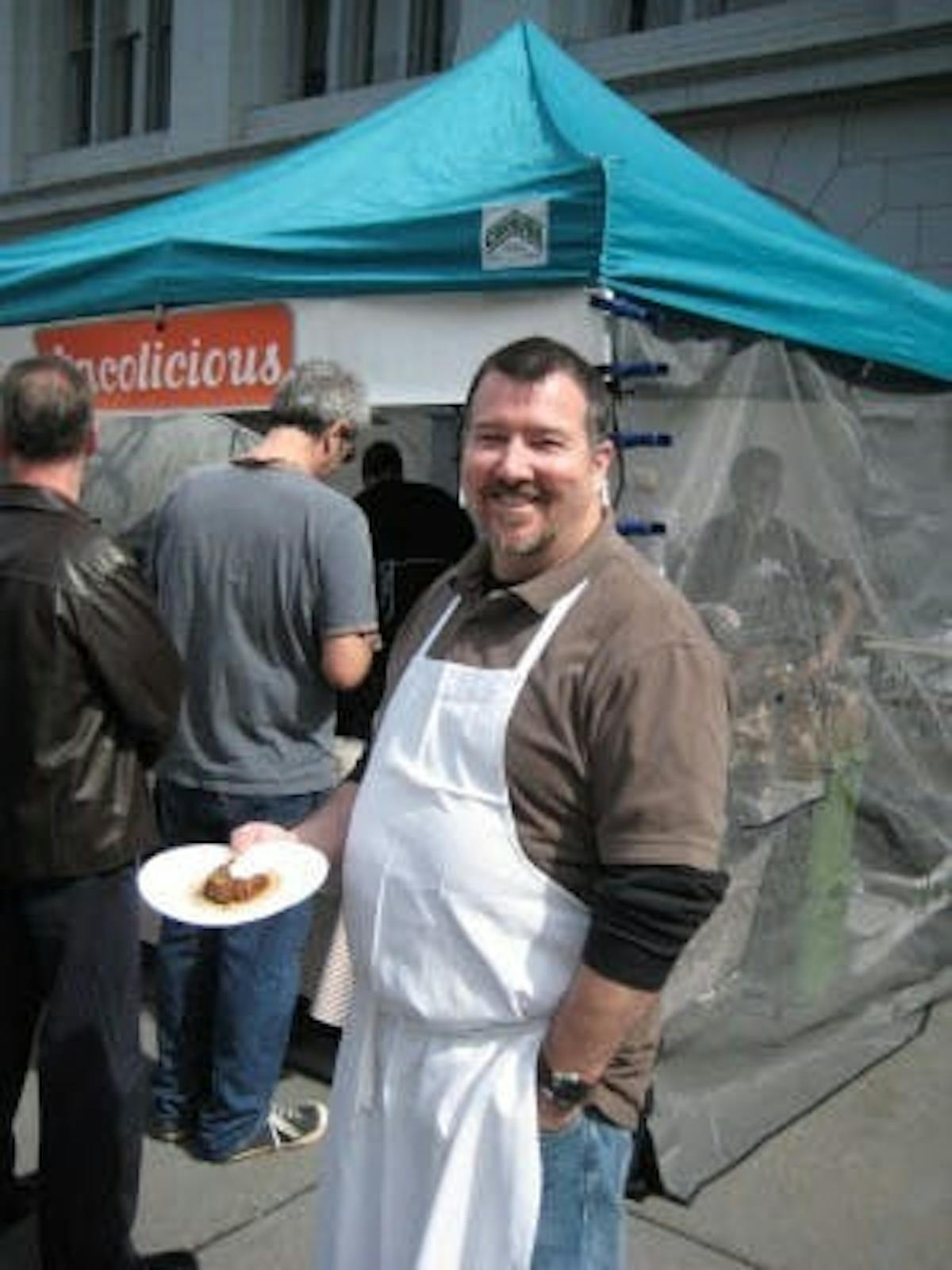 chef mark posing outside holding a taco