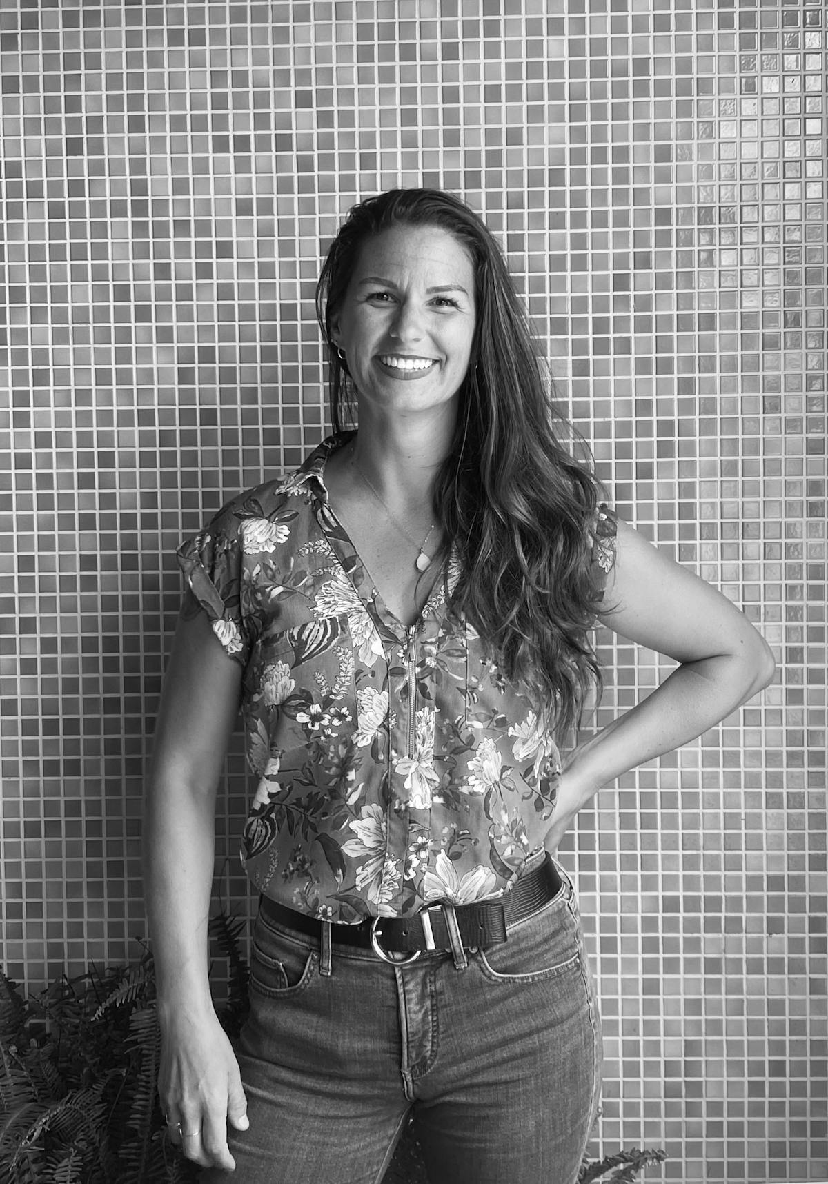 Long-haired woman in floral blouse smiling for the camera