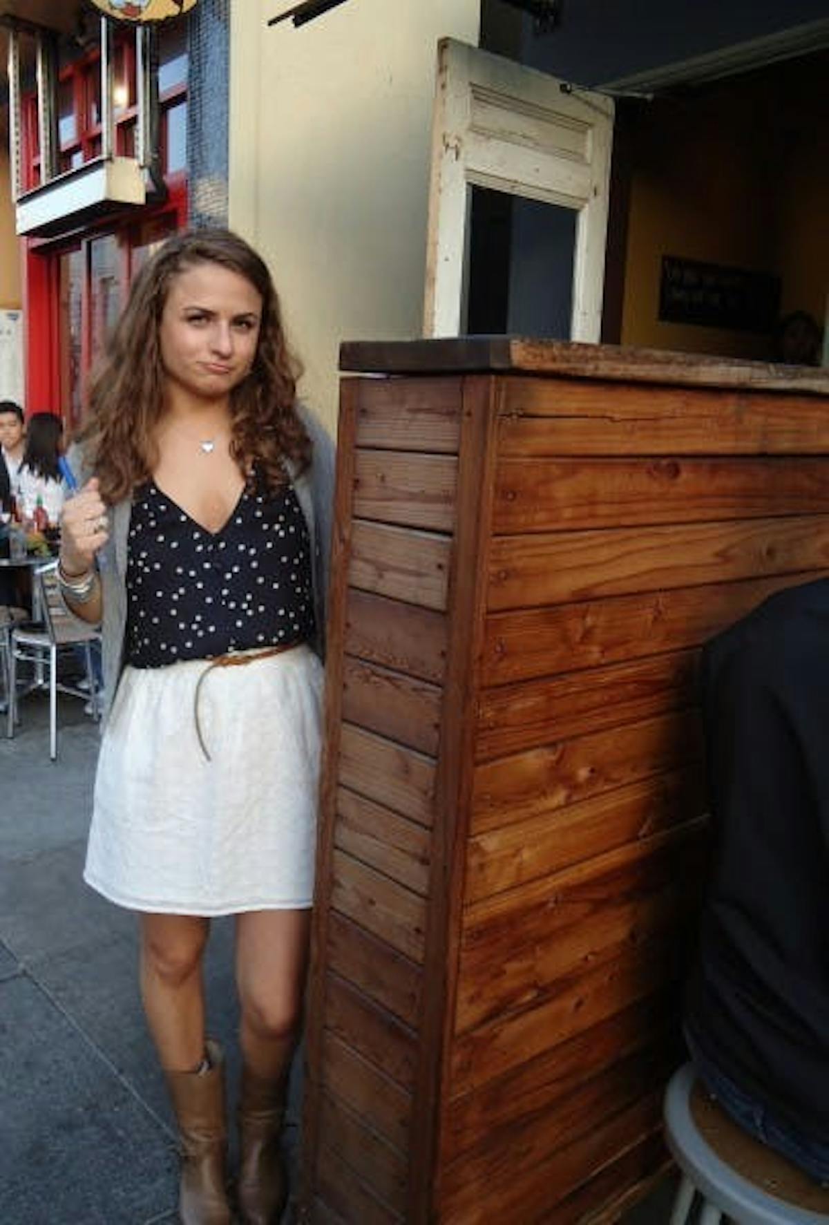 a woman posing near a wooden corner