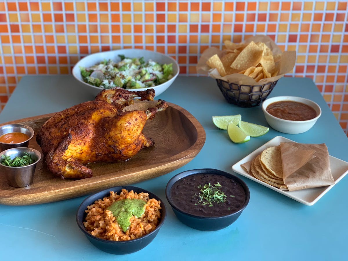 a platter with roasted chicken and side dishes