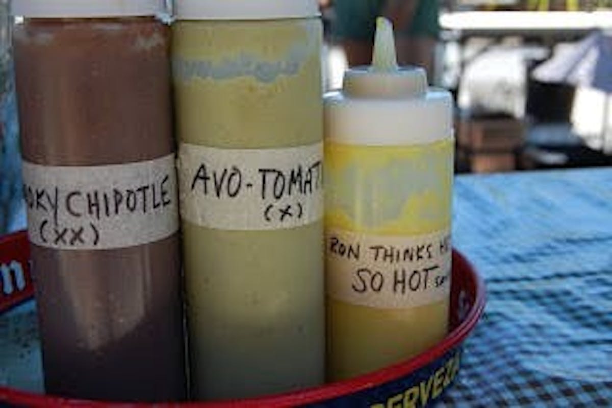 three bottles of chipotle, avo tomato, and a yellow sauce